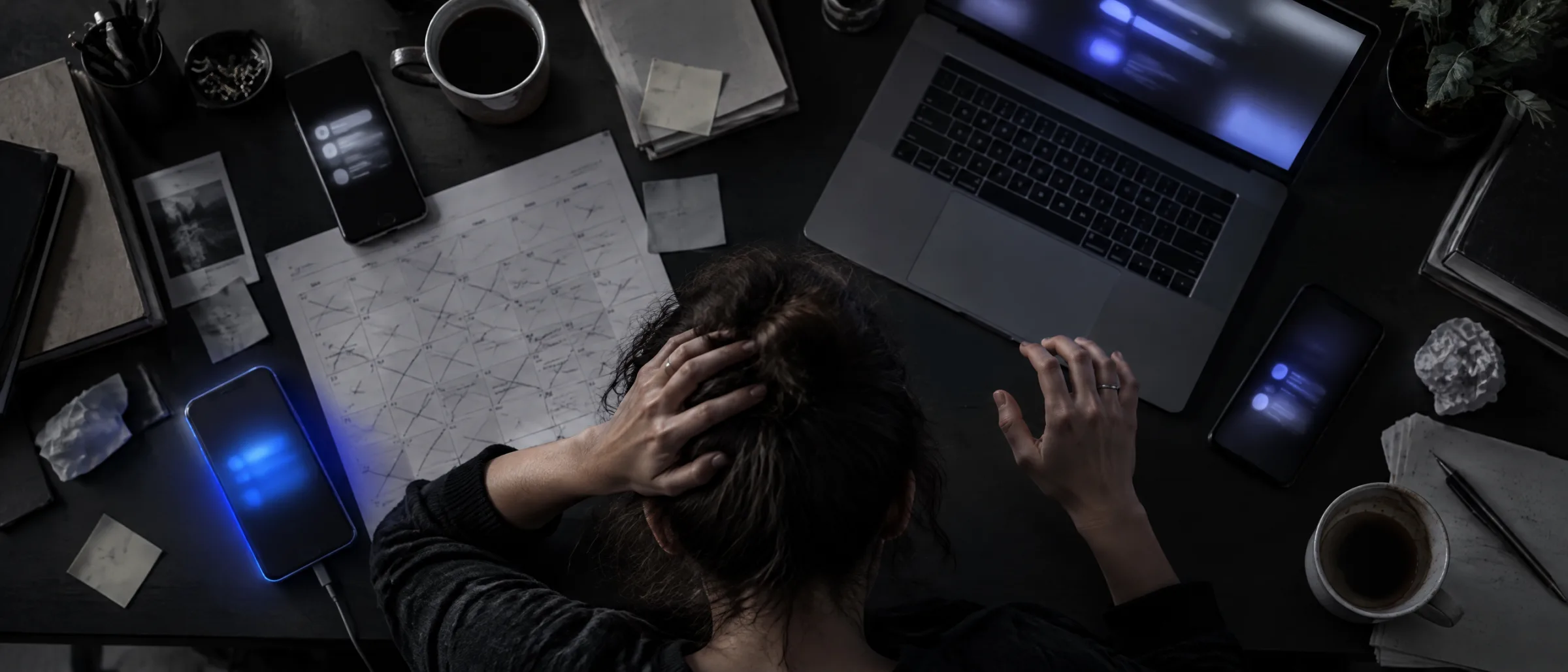 A business owner surrounded by many devices and sticky notes, looking overwhelmed